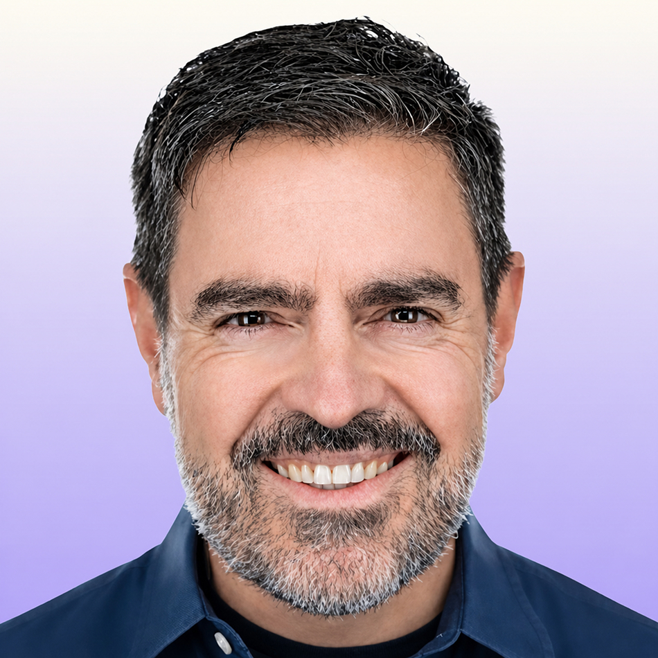 Headshot of Xavi Amatriain smiling at the camera, with a dark collared shirt against a light purple gradient background.