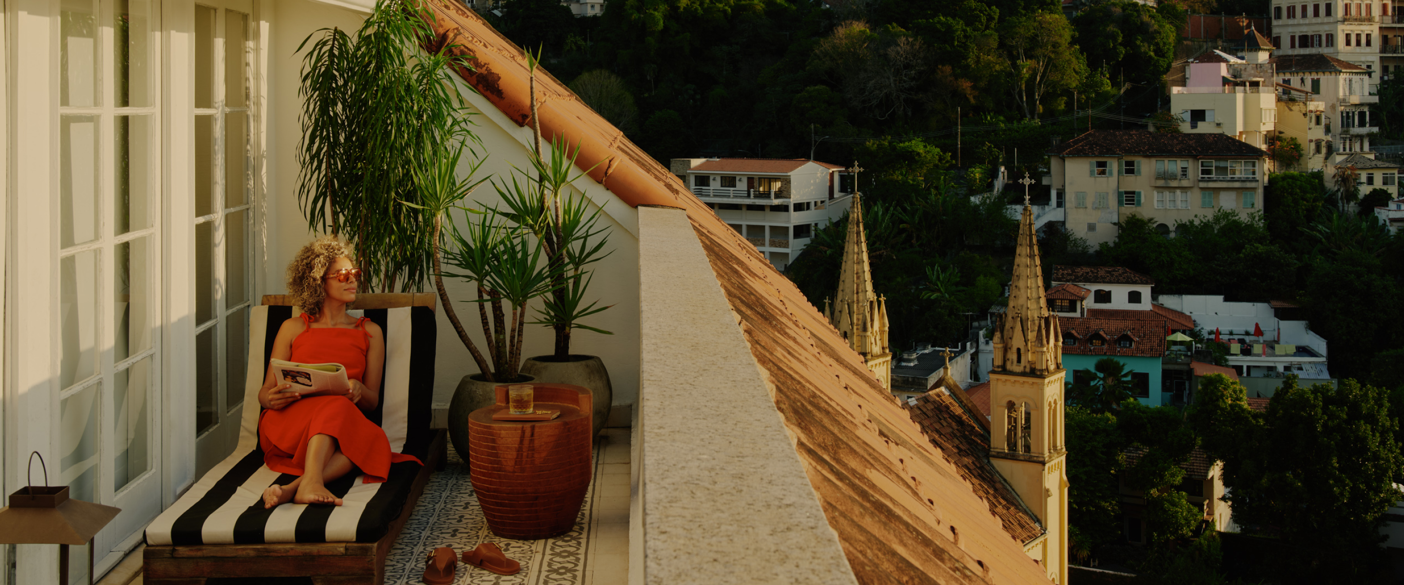 Woman holding a magazine and looking into the distance on a balcony