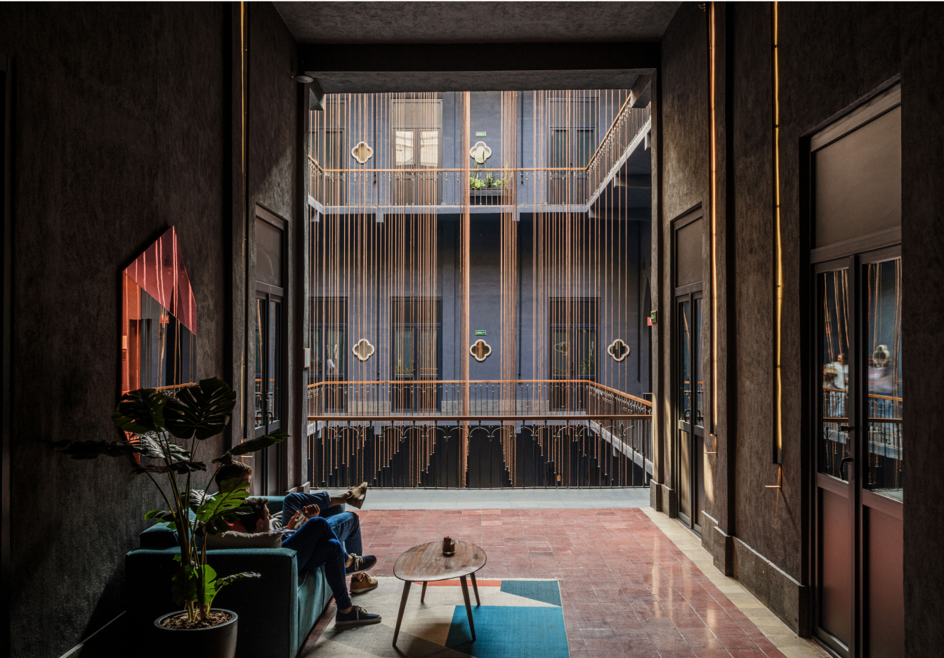 Couple sitting on couch in a dark hotel lobby.