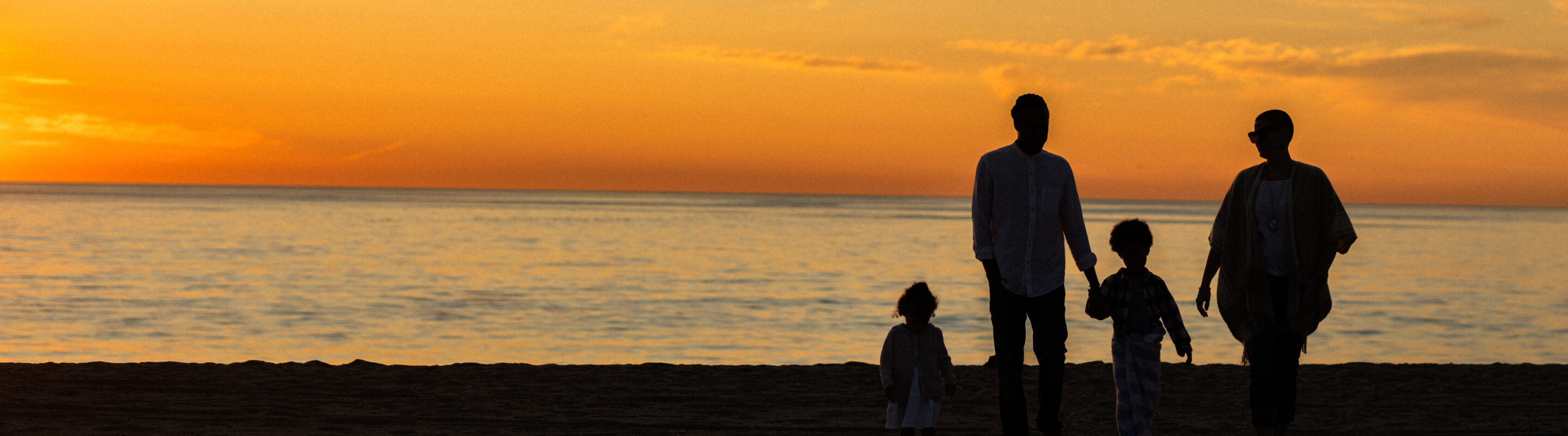 A family watching the sunset on a beach in Los Angeles
