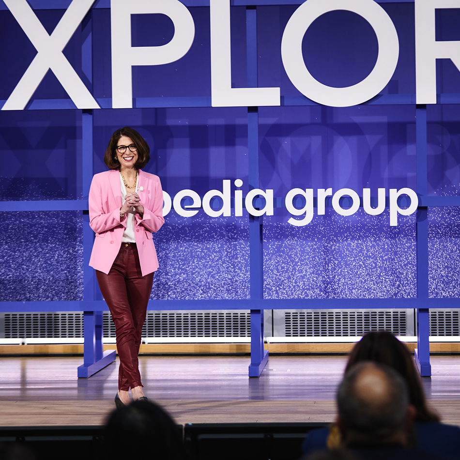Ariane Gorin speaking on stage at a EXPLORE event.