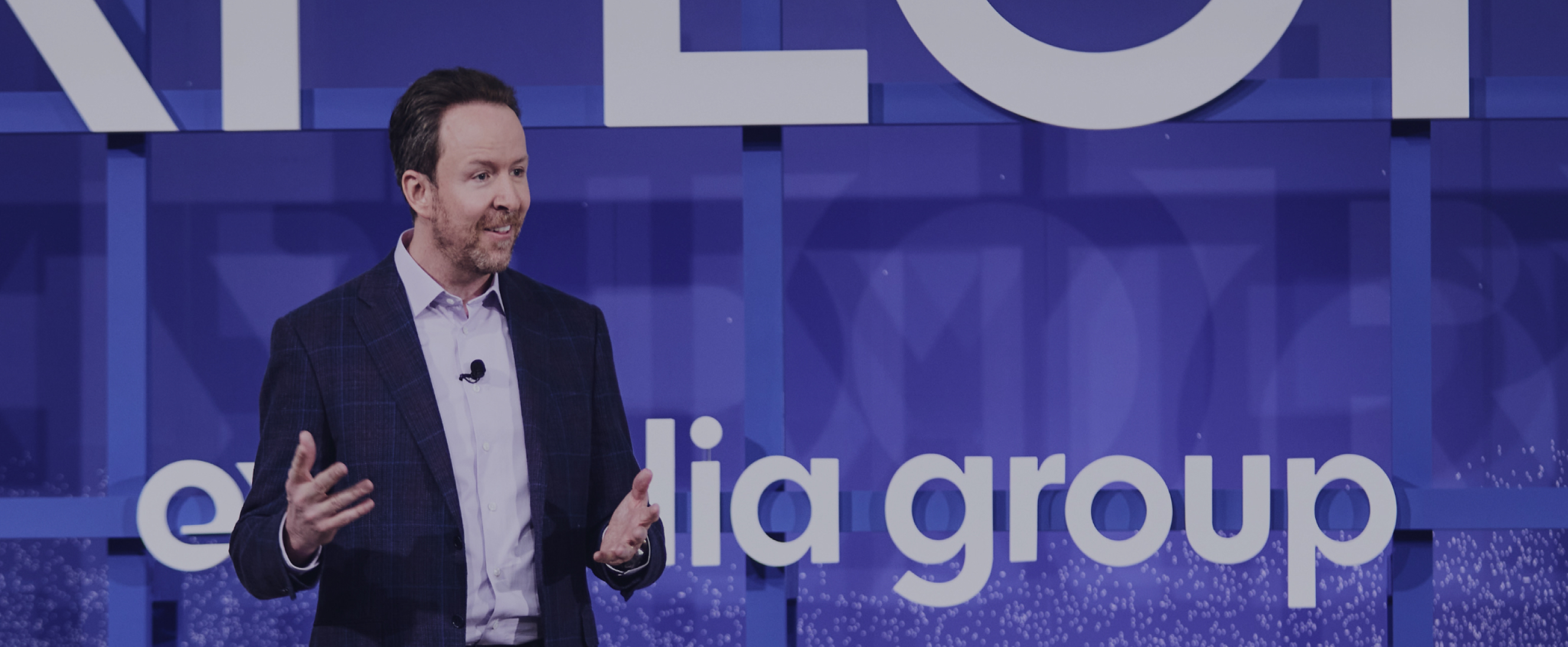Greg Schulze, Chief Commercial Officer, speaking on stage during an Expedia Group EXPLORE event.