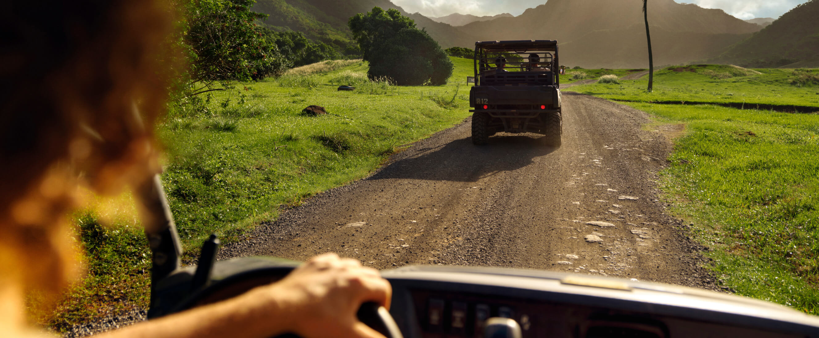 A jeep on safari following another jeep on a dirt road