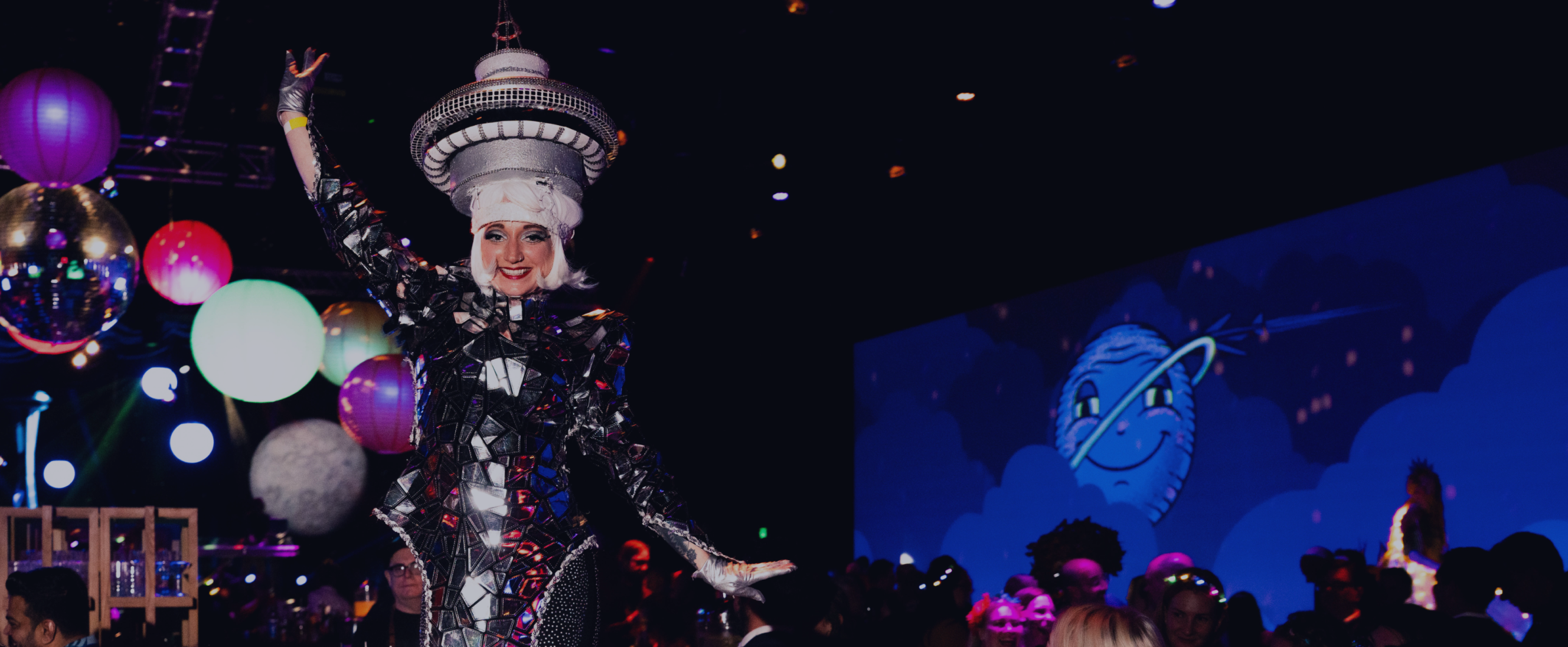 Performer in an elaborate themed costume poses in an event space.