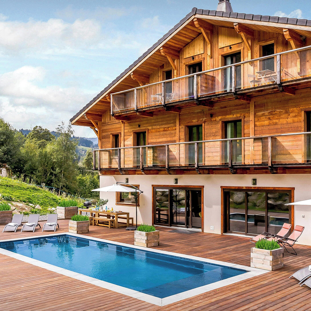 Photograph of a modern wooden house with a pool