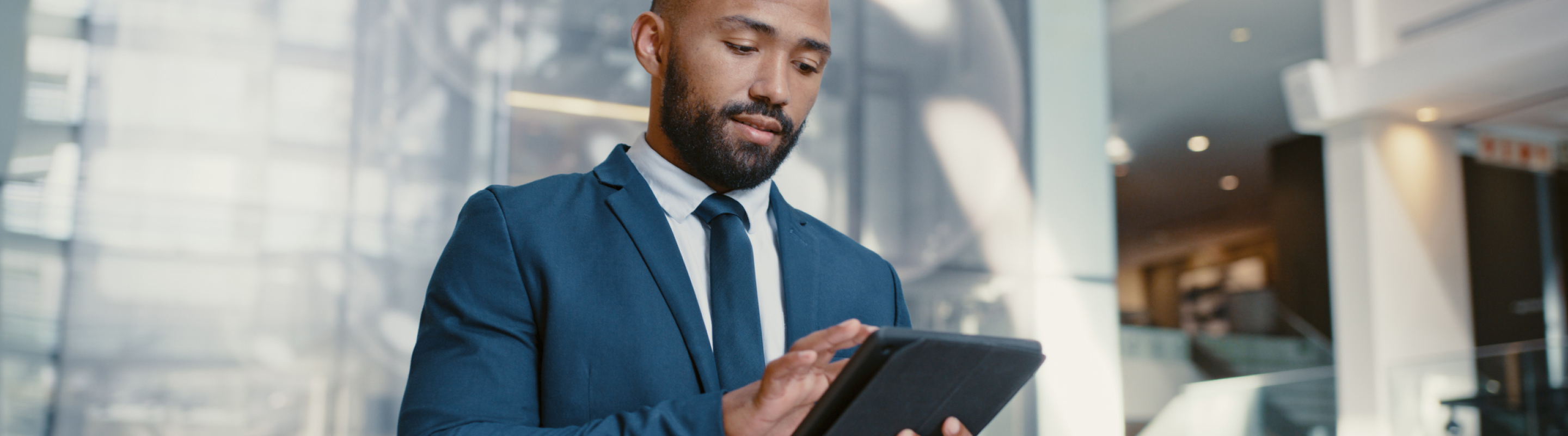 A man in suit checking something on his tablet
