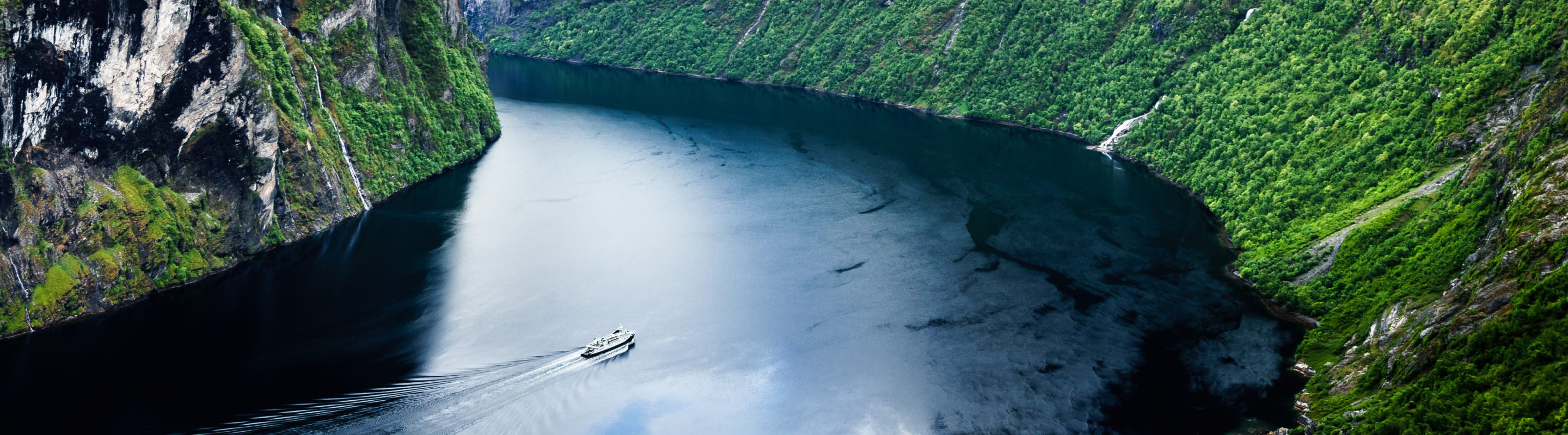  Cruise ship sailing between mountains.