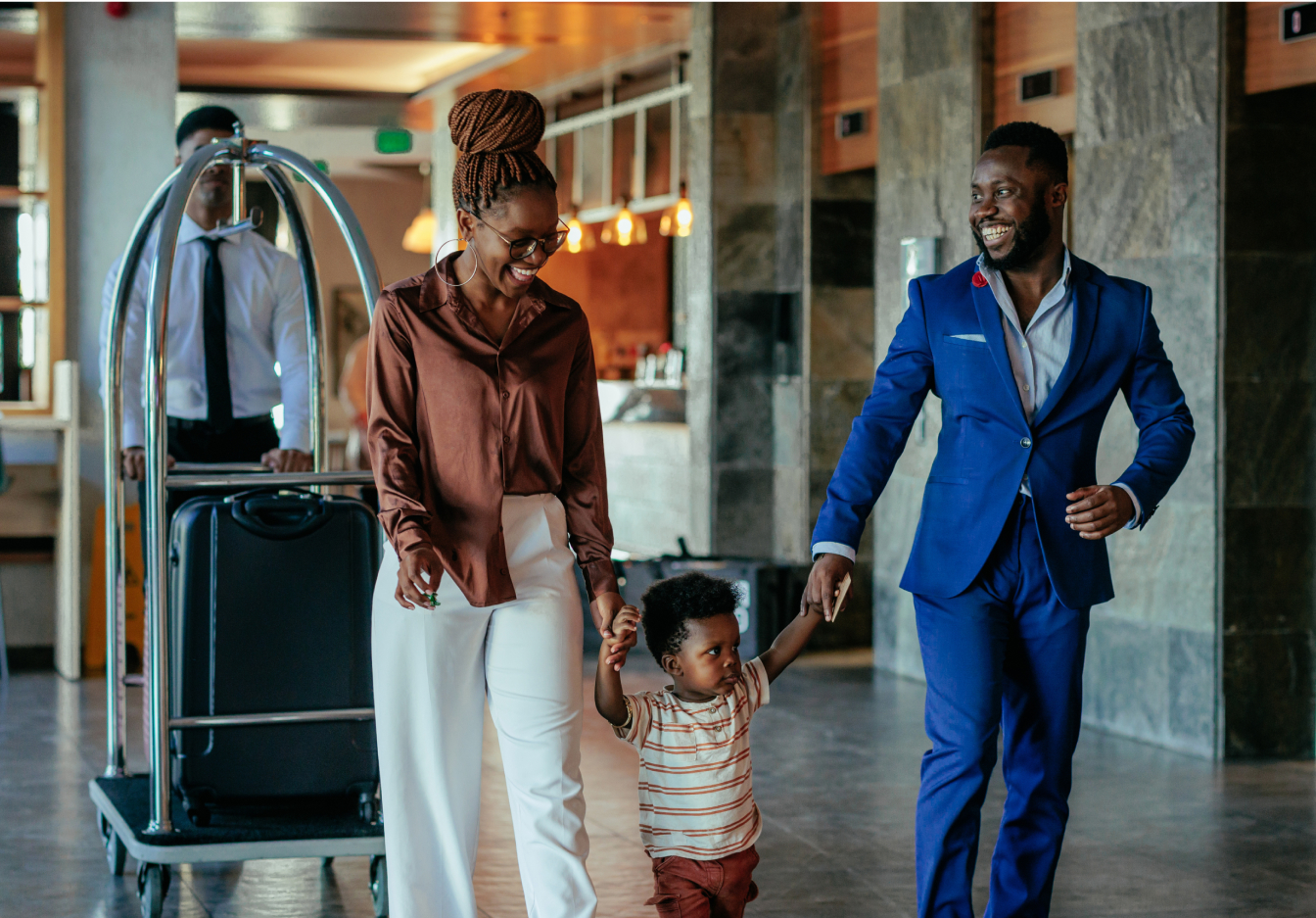 Family arriving at a hotel with luggage, greeted by a hotel staff member, capturing a warm and welcoming guest experience.
