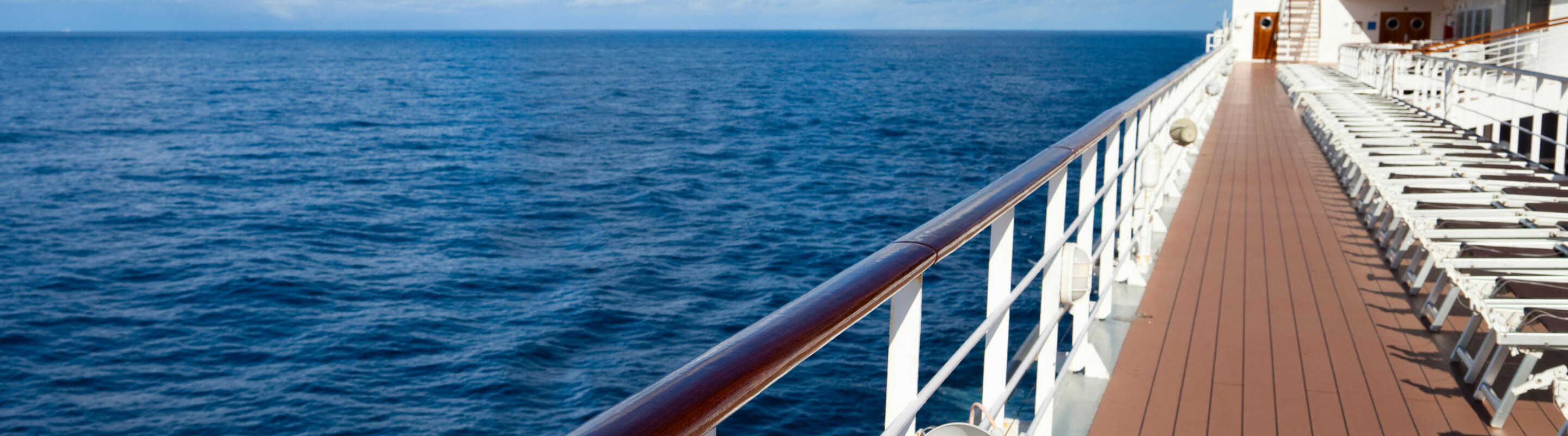 An image of the ocean while looking down the deck of a large ship