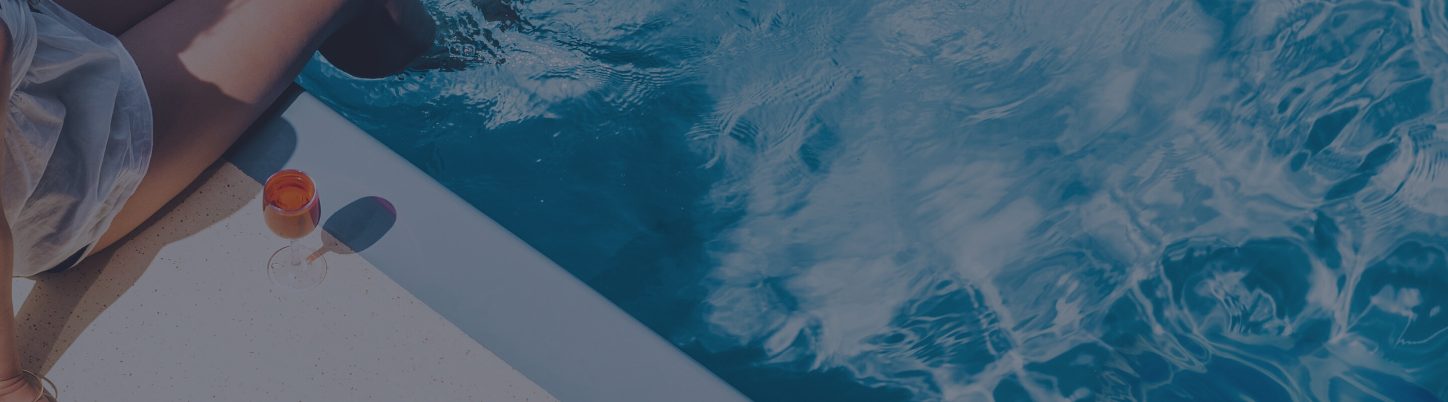 Close-crop of a woman sitting with her feet in a pool